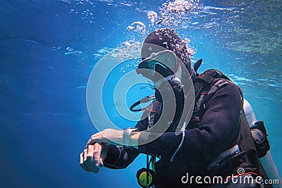 Fully equipped man scuba diver underwater in the blue water Stock Photo