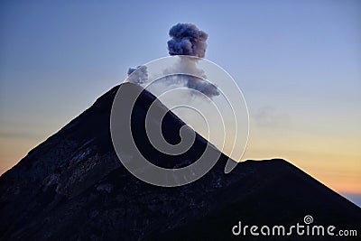 Fuming silhouette of an eruption of active volcano Fuego in Guatemala. Stock Photo