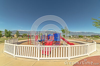 Fun colorful childrens playground overlooking lake snowy mountain and blue sky Stock Photo