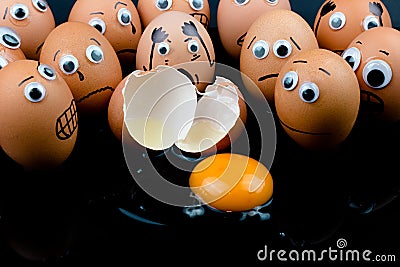 Fun concept: raw eggs with googly eyes and drawn features in shock witness another egg broken in front of them Stock Photo