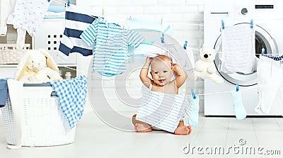 Fun happy baby boy to wash clothes and laughs in laundry Stock Photo