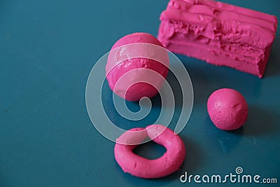 Fun plasticine texture painted on a modeling board. Toying with pink plasticine. Consists of the plasticine. Modeling figure. Lett Stock Photo