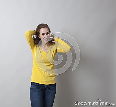 Fun 20s girl putting her hair in shape for the photo shot Stock Photo