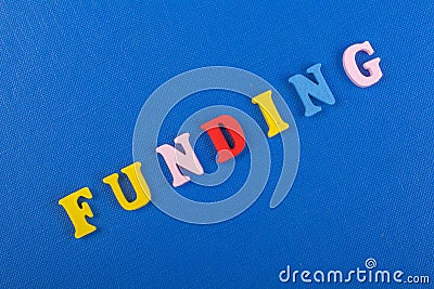 FUNDING word on blue background composed from colorful abc alphabet block wooden letters, copy space for ad text. Learning english Stock Photo