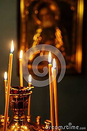 funeral candles burn on altar in front of icon Stock Photo