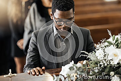 Funeral coffin, death and black man sad, grieving and mourning loss of family, friends or dead loved one. Church service Stock Photo