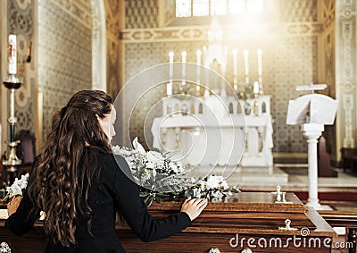 Funeral coffin, death and woman in church after the loss of family, friend or loved one from cancer. RIp, mourning and Stock Photo