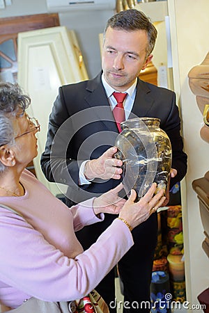 Funeral director with widow choosing urn Stock Photo