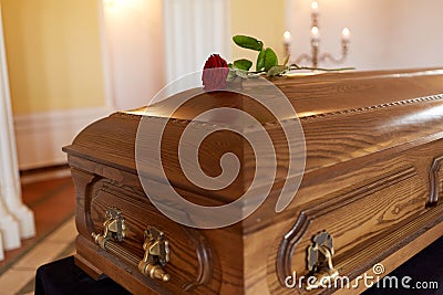 Red rose flower on wooden coffin in church Stock Photo