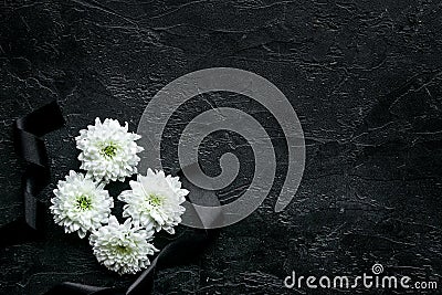 Funeral symbols. White flower near black ribbon on black background top view copy space Stock Photo