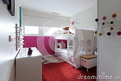 Funky kids bedroom with red carpet and pink painted wall Stock Photo