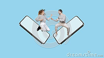 Funne design. Collage of cheerful man and woman jumping out phone screen and jokingly fighting isolated over blue Stock Photo