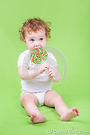 Funny adorable baby with a big candy Stock Photo