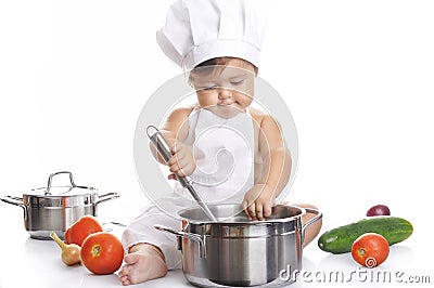 Funny adorable baby boy chef sitting and playing Stock Photo