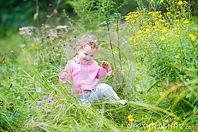 Funny adorable baby girl walking in the garden Stock Photo