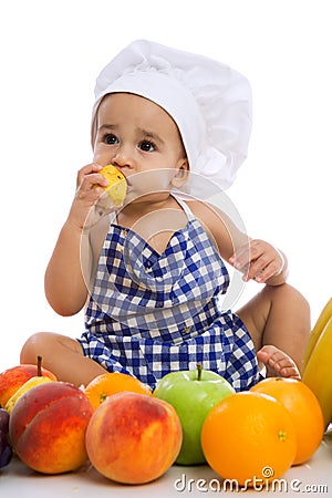 Funny adorable baby with green apples and different fruits Stock Photo