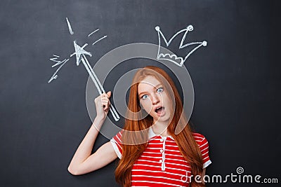 Funny amazed woman with drawn crown standing over blackboard background Stock Photo