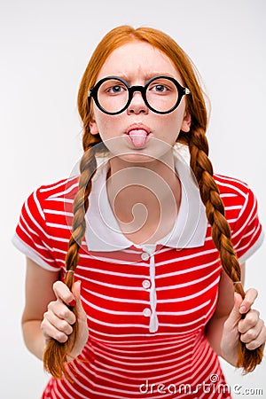 Funny amusing girl in round glasses showing tongue Stock Photo