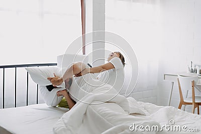 Funny couple morning wake up fight between wife and lazy husband. Stock Photo