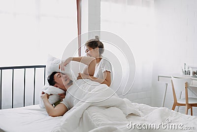 Funny couple morning wake up fight between wife and lazy husband. Stock Photo