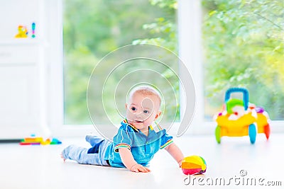 Funny baby boy playing with colorful ball and toy car Stock Photo