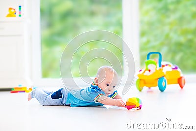 Funny baby boy playing with colorful ball and toy car Stock Photo