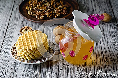 Funny baby jar of honey with a pink honey spoon and walnuts and waffle cookies Stock Photo