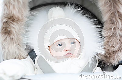 Funny baby in a warm stroller on a cold winter day Stock Photo