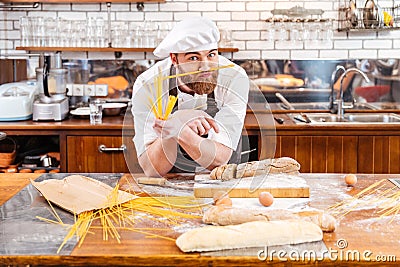 Funny baker making moustache using macarons on the kitchen Stock Photo