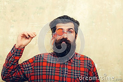 Funny bearded man holding red heart on stick before eye Stock Photo