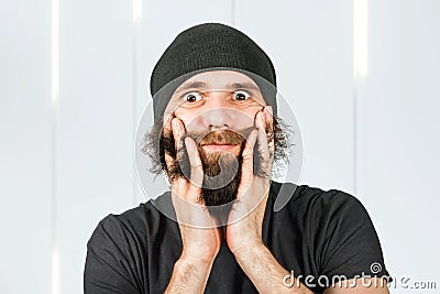 Funny bearded young man touch and combing his beard Stock Photo