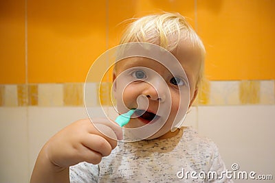 Funny blonde baby child brushing teeth Stock Photo