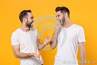 Funny boring young men guys friends in white t-shirts posing isolated on yellow orange background. People lifestyle Stock Photo