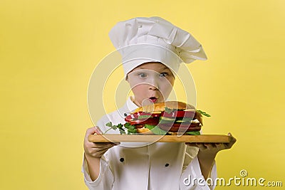Funny boy chef cooked a big hamburger Stock Photo