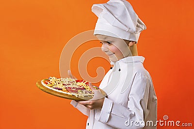 Funny boy chef cooked pizza on a board Stock Photo