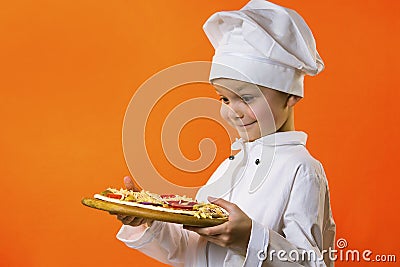 Funny boy chef cooked pizza on a board Stock Photo