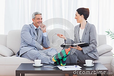 Funny businessman wearing stripey socks and laughing with his co Stock Photo