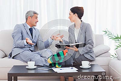 Funny businessman wearing stripey socks and talking with his col Stock Photo