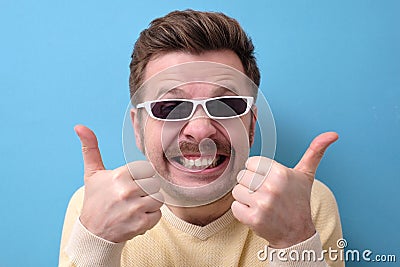 Funny caucasian man with retro mustache and sunglasses giving a thumbs up Stock Photo