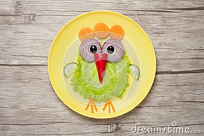 Funny chicken made of vegetables on plate and desk Stock Photo