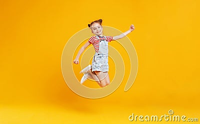 Funny child girl jumping on colored yellow background Stock Photo