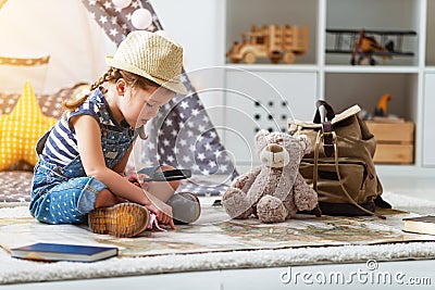 Funny child girl tourist with world map, backpack and magnifier Stock Photo