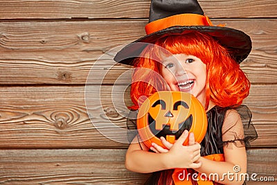 Funny child girl in witch costume for Halloween with pumpkin Ja Stock Photo