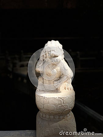 A funny Chinese stone lion standing on a stone pillar Stock Photo