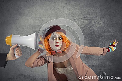 Funny clown hears a megaphone with a message Stock Photo