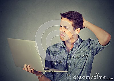 Funny clueless guy having troubles with laptop. Complicated technology Stock Photo