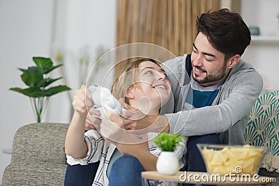 Funny couple on couch at home Stock Photo