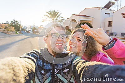 Funny couple With Keys Standing Outside New Home. Real estate, owner and people concept Stock Photo