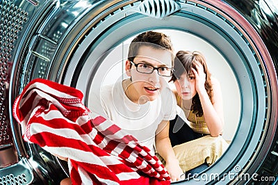 Funny couple loading clothes to washing machine Stock Photo