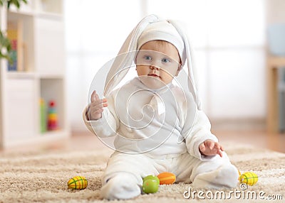 Cute baby child in rabbit costume sittng on froor in nursery Stock Photo